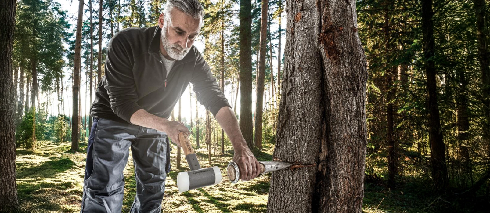 Mann mit Hammer im Wald